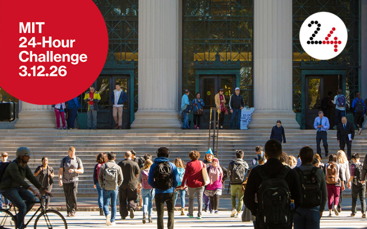 People walking and biking past columns on an MIT building