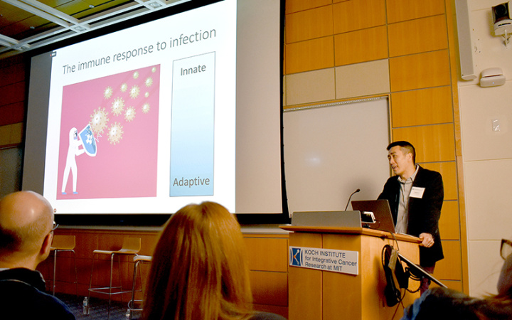 Hojun Li at a lectern showing a slide illustrating immune response to infection