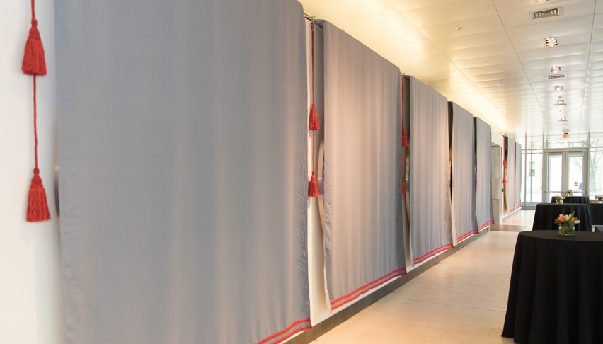 drapes hang over large displays in an empty gallery