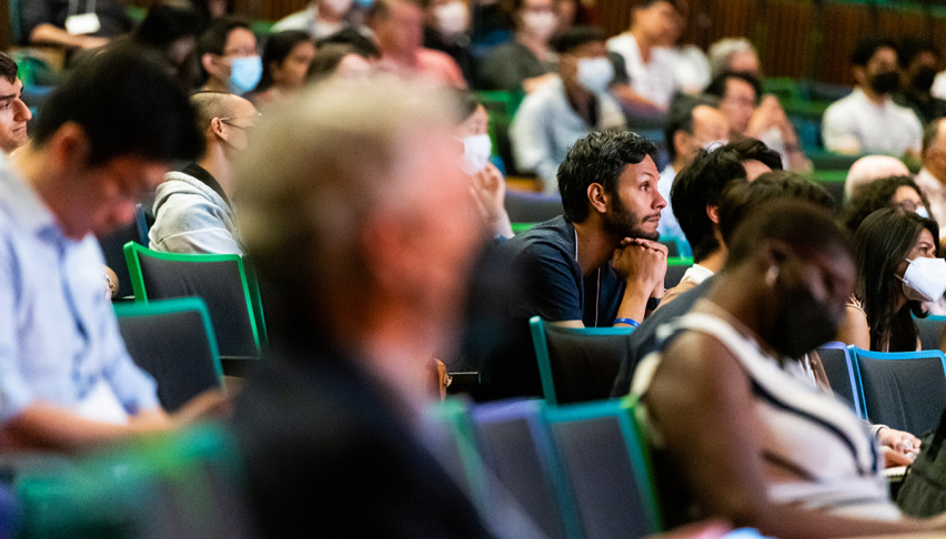 People in an auditorium, listening