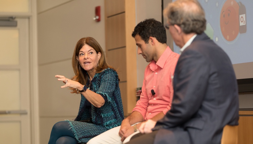 three people conversing on a panel