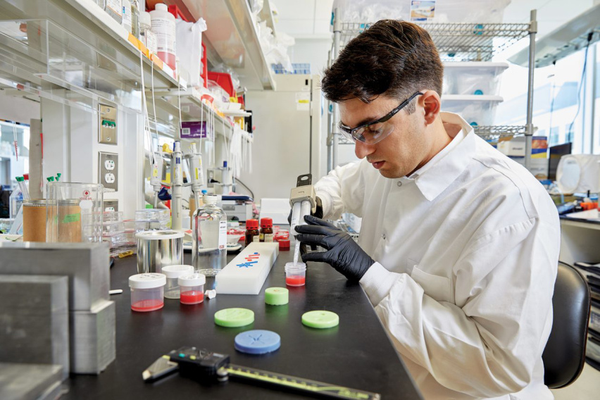 Greg Ekchian pipetting at the lab bench.