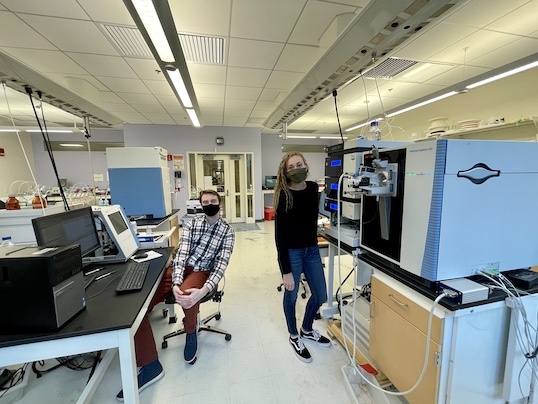 Lauren and Cam in the lab with equipment surrounding