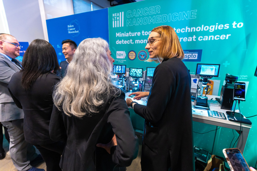 Two women in discussion at an exhibition booth