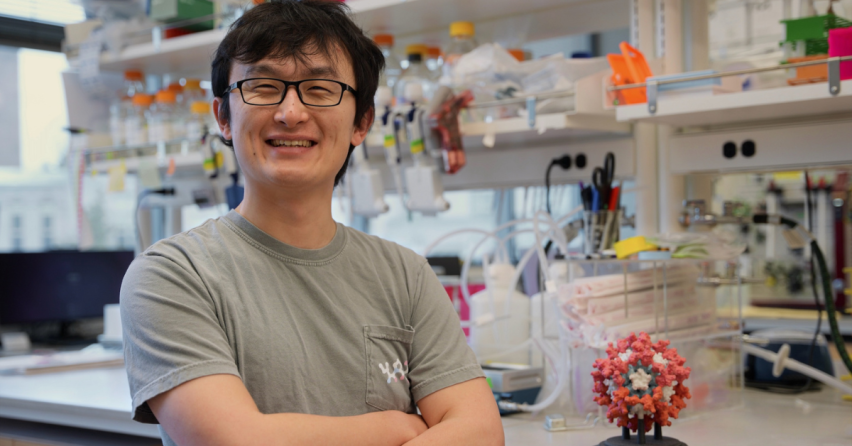 Bingxu Li, smiling and arms crossed, standing in a lab