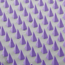 alse-colored scanning electron microscope image of dozens of microneedles arranged in a grid 