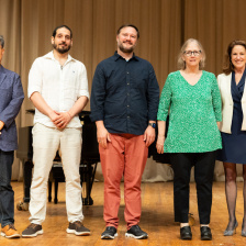 Five people standing in a row on a stage