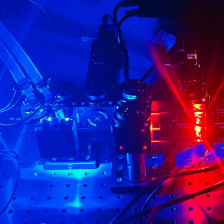 Blue and red light show a microscope and lab setup.