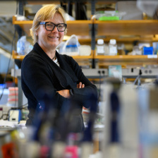 Photo of Linda Griffith, wearing a black blazer, in her laboratory