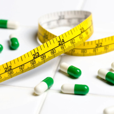 Photo of a tape measure and green and white pills