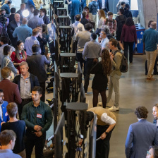 A group of people looking at poster presentations in an MIT building 