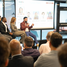 A group of people sitting on stage during a panel discussion