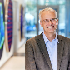 Photo of Matthew Vander Heiden, standing in the Koch Institute gallery and smiling for the camera. 