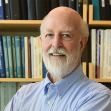 Headshot of Richard Hynes, sitting in front of a bookcase