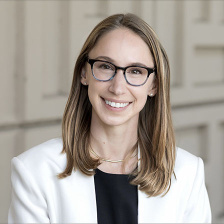 Photo of woman with blonde shoulder-length hair and glasses smiling at the camera