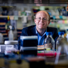 Michael Birnbaum in the lab, with blurry equipment in the foregroun