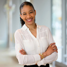 Photo of Whitney Henry, wearing a white blouse, and smiling for the camera