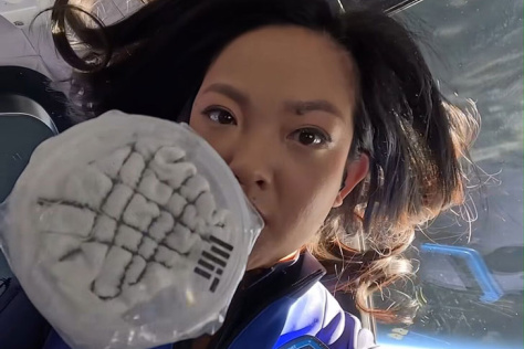 A woman takes a selfie with an ultrasound device in space.