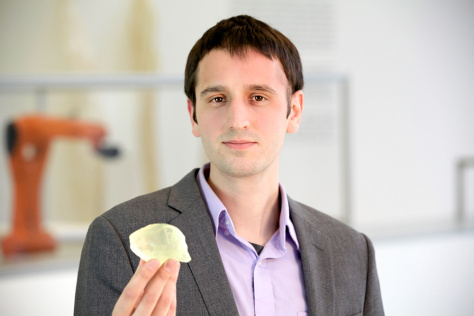 Steven Keating holding up a 3D printed copy of his brain tumor