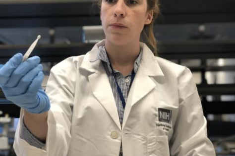 Kaitlyn Sadtler holds up a microsampling device