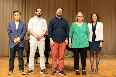 Five people standing in a row on a stage
