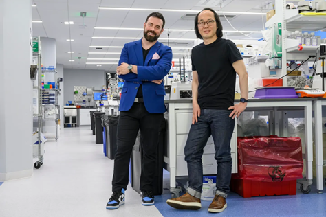 Strand Therapeutics founders Jake Becraft (left) and Tasuku Kitada standing in a lab