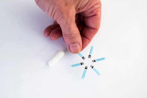 A hand holds one prong of a star-shaped, six-pointed device