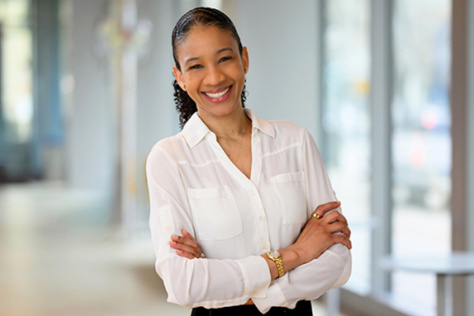 Photo of Whitney Henry, wearing a white blouse, and smiling for the camera