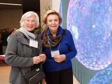 Two women in front of an image in the Koch Institute Public Galleries
