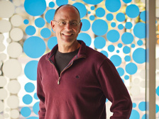 A man standing in front of a window covered in blue dots